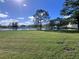Spacious backyard with a pond view, lush grass and mature trees at 3040 Palermo Rose Way, Kissimmee, FL 34746