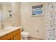 Clean bathroom with wood vanity, shower, and butterfly-themed curtain at 429 Danube Dr, Poinciana, FL 34759