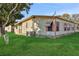 Side view of a tan mobile home with a green lawn at 450 Tivoli Park Dr, Davenport, FL 33897