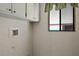 Small laundry area with upper cabinets and a window at 450 Tivoli Park Dr, Davenport, FL 33897
