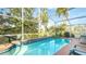 Screened-in pool with lounge chairs and a table at 223 Lake Davenport Estates, Davenport, FL 33897