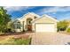 House exterior features a two-car garage and a landscaped yard at 223 Lake Davenport Estates, Davenport, FL 33897