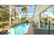 Screened-in pool with lounge chairs and a table at 223 Lake Davenport Estates, Davenport, FL 33897