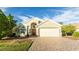 Tan house with a two-car garage and a red door at 223 Lake Davenport Estates, Davenport, FL 33897