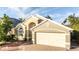 House exterior featuring a two-car garage and solar panels at 223 Lake Davenport Estates, Davenport, FL 33897