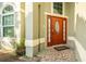 Orange front door with a decorative glass oval at 223 Lake Davenport Estates, Davenport, FL 33897