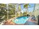 Screened-in pool with lounge chairs and a table at 223 Lake Davenport Estates, Davenport, FL 33897
