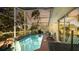 Screened-in pool with lounge chairs and a table at 223 Lake Davenport Estates, Davenport, FL 33897