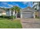 House exterior showcasing a two-car garage and manicured lawn at 520 Vista Oaks Way, Davenport, FL 33837