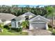 Two-story house with light beige exterior and a two-car garage at 520 Vista Oaks Way, Davenport, FL 33837