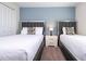 Bedroom with two twin beds, nightstand, and blue accent wall at 4845 Romeo Cir, Kissimmee, FL 34746
