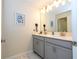 Double vanity bathroom with modern gray cabinets and a large mirror at 4845 Romeo Cir, Kissimmee, FL 34746