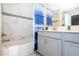 Bathroom with a bathtub, gray vanity, and blue shower curtain at 4845 Romeo Cir, Kissimmee, FL 34746