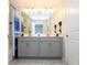 Double vanity bathroom with gray cabinets and a large mirror at 4845 Romeo Cir, Kissimmee, FL 34746