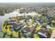 An aerial view of a neighborhood with tile roofs, surrounded by lush greenery and a tranquil lake at 513 Viterra Ct, Kissimmee, FL 34759