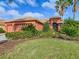 Front exterior of a single-Gathering home with a tile roof, three-car garage, and decorative shrubs at 513 Viterra Ct, Kissimmee, FL 34759