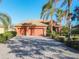 Front exterior of a single-Gathering home with a paver driveway, three-car garage, and lush landscaping at 513 Viterra Ct, Kissimmee, FL 34759