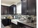 Modern kitchen with dark cabinets, granite countertops, and a farmhouse sink at 12254 Sandy Apple Rd, Orlando, FL 32824