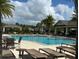Community pool with lounge chairs, tables, and covered seating at 12254 Sandy Apple Rd, Orlando, FL 32824