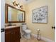 Elegant powder room with dark wood vanity, decorative mirror, and art at 1542 Sun Meadow Dr, Orlando, FL 32824