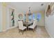 Elegant dining room with a large wooden table, chandelier, and white chairs at 1542 Sun Meadow Dr, Orlando, FL 32824