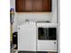 Laundry room with washer, dryer, and ample cabinet space at 13010 Stoddart Ave, Orlando, FL 32827