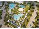 Aerial view of resort-style community pool, showing multiple pools, a sandy beach area, and a basketball court at 13010 Stoddart Ave, Orlando, FL 32827