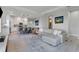 Open living room with large sectional sofa, modern TV stand and kitchen views at 13010 Stoddart Ave, Orlando, FL 32827