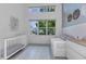Bedroom with crib, daybed, and large windows at 13010 Stoddart Ave, Orlando, FL 32827
