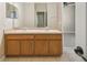 Double vanity bathroom with wood cabinets at 3381 Marshfield Preserve Way, Kissimmee, FL 34746