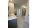 Main bathroom with double vanity, shower, and tile flooring at 2893 Fitness St, Clermont, FL 34714
