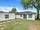 Backyard view showing a single story home with sliding glass doors and grassy area at 117 W Maple St, Davenport, FL 33837