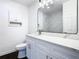 Modern bathroom with white vanity, marble tile, and large mirror at 117 W Maple St, Davenport, FL 33837