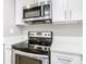 Stainless steel range and microwave in a white kitchen at 117 W Maple St, Davenport, FL 33837