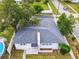 Aerial view of a single-story house with a gray roof and a small above ground pool in the backyard at 117 W Maple St, Davenport, FL 33837