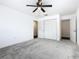 Bedroom with ceiling fan, grey carpet, and ample closet space at 117 W Maple St, Davenport, FL 33837