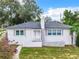 Newly renovated single story home exterior with gray roof, white siding and landscaping at 117 W Maple St, Davenport, FL 33837