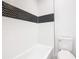 Bathroom with white tub, toilet and black and white herringbone patterned tile at 117 W Maple St, Davenport, FL 33837