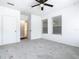Bright bedroom with ceiling fan, grey carpet, and two windows at 117 W Maple St, Davenport, FL 33837