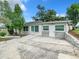 Single story home exterior with gray roof, white siding, stone accents and a driveway at 117 W Maple St, Davenport, FL 33837