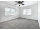 Bright bedroom with ceiling fan, new carpet, and two large windows at 117 W Maple St, Davenport, FL 33837