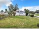 Single-story house exterior with a gray roof, white siding, and landscaping at 117 W Maple St, Davenport, FL 33837