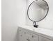 Modern bathroom with white vanity, round mirror, and black fixtures at 117 W Maple St, Davenport, FL 33837
