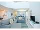 Open living room with gray sectional sofa and large TV at 4839 Kings Castle Cir, Kissimmee, FL 34746