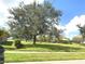 Community park with large trees, grassy areas and gazebo under a partly cloudy sky at 2109 Woodsedge Dr, Kissimmee, FL 34746