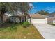 Front view of a one-story house with a beige exterior and a neatly landscaped yard at 111 Herring Way, Kissimmee, FL 34759