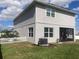 Rear view of two-story house with gray siding, screened porch, and AC unit at 4531 Brooksshire Pl, Lake Wales, FL 33898