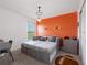 Stylish bedroom with an orange accent wall and twin beds at 4743 Magnetite Loop, Mount Dora, FL 32757