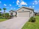 Tan house with a two-car garage and landscaping at 4743 Magnetite Loop, Mount Dora, FL 32757