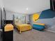 Bedroom with yellow bedding and a blue sofa at 4743 Magnetite Loop, Mount Dora, FL 32757